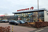 Firmengebäude von Batavius mit Glasfenstern und Parkplatz vor dem Haus.