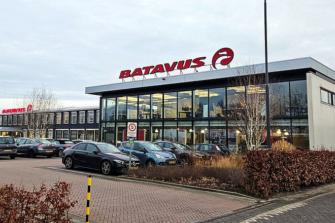 Firmengebäude von Batavius mit Glasfenstern und Parkplatz vor dem Haus.