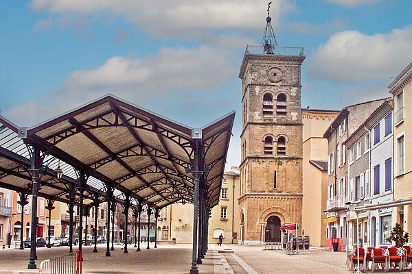 Platz mit Sonnendächern vor einer Kirche.