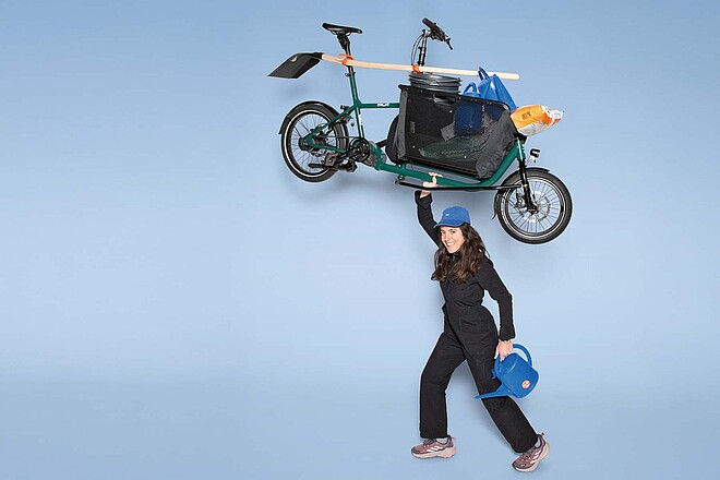 Eine Frau hebt ein Fahrrad in die Luft