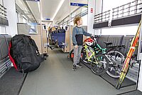 Auf die neue Saison hin können Velofahrende von etlichen  Verbesserungen beim Veloverlad profitieren. Ein Kind steht neben einem Fahrrad in einem Zugabteil.