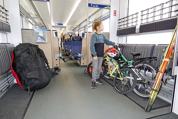 Auf die neue Saison hin können Velofahrende von etlichen  Verbesserungen beim Veloverlad profitieren. Ein Kind steht neben einem Fahrrad in einem Zugabteil.