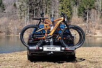 Heckträger «Almada Work-E» von XLC. Zwei gelbe E-Mountainbikes sind auf einem Heckträger am Kofferraum eines Autos befestigt.