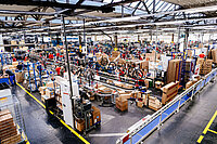 Arbeiterinnen und Arbeiter montieren in einer Fabrik neue Fahrräder