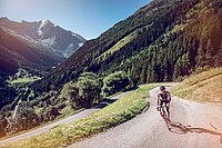 Ein Rennradfahrer erklimmt eine autofreie Passstrasse inmitten der Walliser Berglandschaft