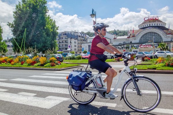 Locker durch die Schweiz radeln: Vier Routen zwischen Bodensee und Genfersee. Eine Frau fährt auf einem E-Trekkingrad.
