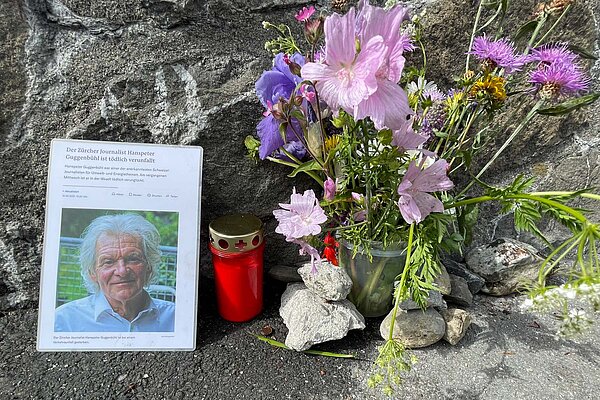 Gedenktafel für einen getöteten Radfahrer mit Blumen und Kerzen