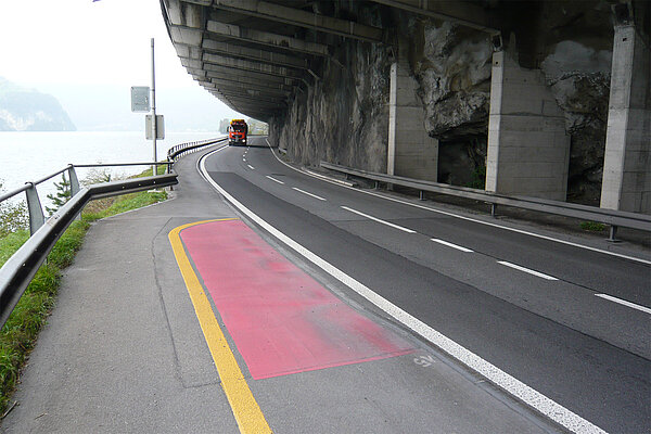 Alte Velomarkierung in Kurve auf der Axenstrasse