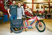 Benno Bikes Portrait. Zwei Männer stehen hinter einem E-Bike. 