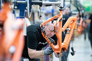 Die Europäische Fahrradindustrie im Krisenmodus. Ein Arbeiter montiert in E-Bike.