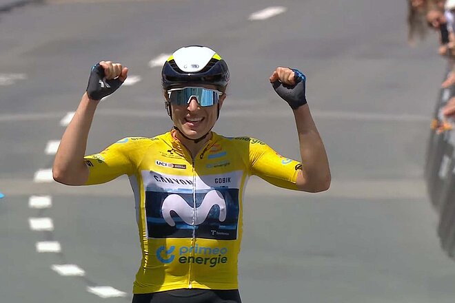 Eine Rennradfahrerin streckt die Hände auf dem Rad in die Luft.