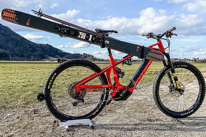 E-Mountainbike das am Rahmen Ski befestigt hat.