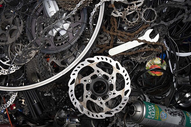 Viele Fahrradteile liegen auf einem Haufen. 