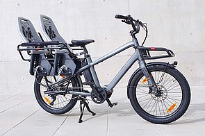 Benno Bikes Potrait. Fahrrad zwei Kindersitzen auf dem Gepäckträger.