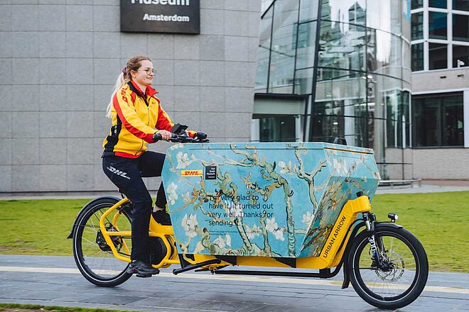 Basel Stadt Wirtschaft unter Strom Subventionen für Cargobikes. Eine Lieferdienstmitarbeiterin fährt auf einem Lastenrad.
