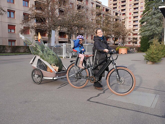 Jelena und Ella bringen ihre Tanne im Anhänger nach Hause.