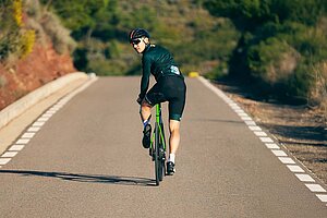 Ein Rennradfahrer blickt nach hinten über die Schulter. 