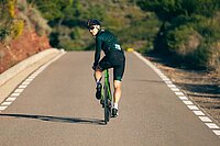 Ein Rennradfahrer blickt nach hinten über die Schulter. 