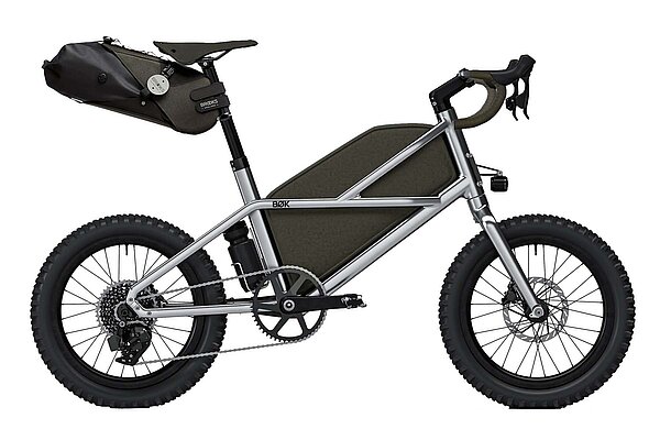 Gravelbike mit kleinen Rädern und Packtaschen an Rahmen und Sattelrohr.