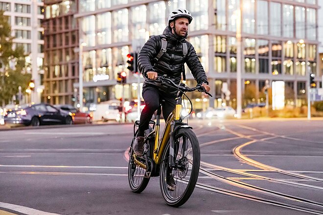 Glaubt man der aktuellen Studie von Inkwood Research, wird der weltweite E-Bike-Boom noch einige Jahre anhalten. E-Bike-Boom hält weiterhin an. Ein Mann mit wetterfester Bekleidung fährt mit einem Elektrovelo in der Stadt Basel.
