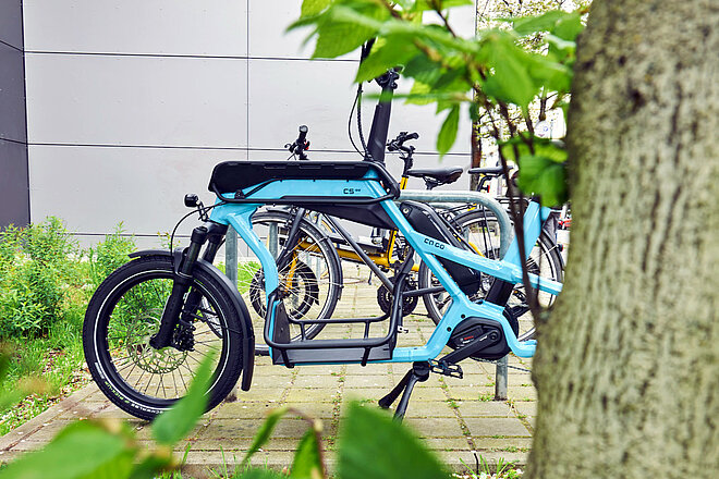 Ca Go CS E-Lastenrad. Ein blaues Cargobike auf einem Parkplatz.