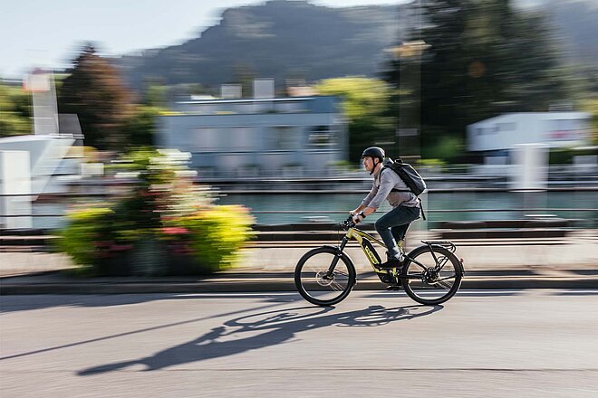 Mann auf E-Bike vor verschwommenem Hintergrund