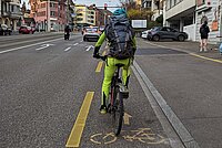 Die Grenzen der Unfallstatistik am Beispiel des Velos. Radfahrer mit gelber Kleidung auf einem Radstreifen. 