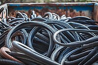 Schwalbe Reifenrecycling. Alte Fahrradreifen liegen in einer Containermulde.
