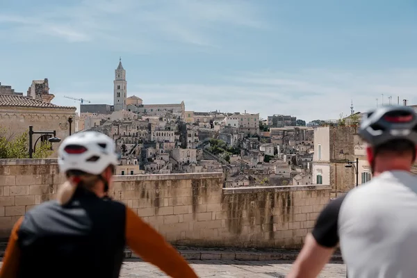Zwei Radfahrer blicken auf die Stadt Matera.