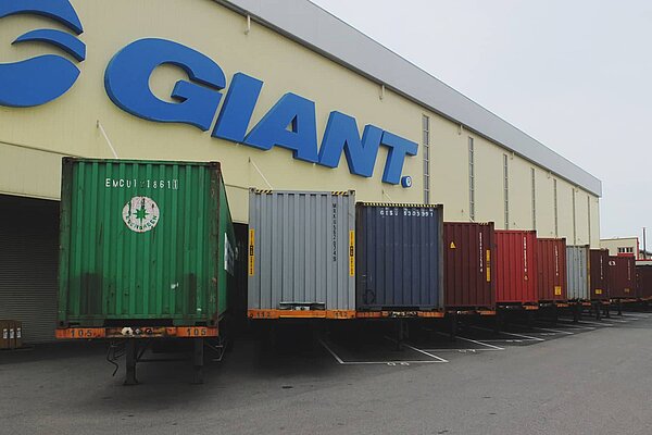 Frachtcontainer stehen vor einem Fabrikgebäude von Giant in Taiwan.