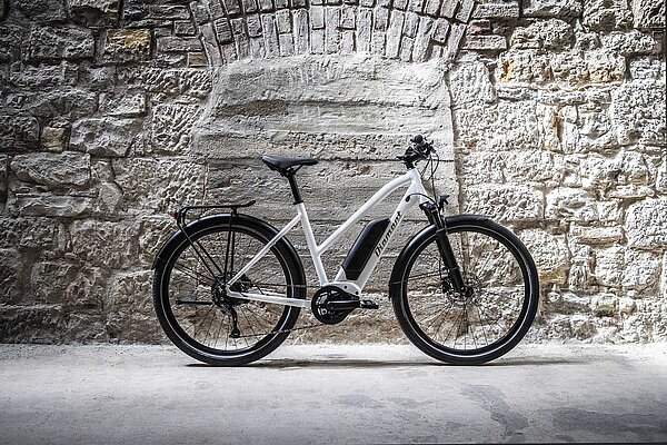 Ein Pedelec steht vor einer Steinmauer