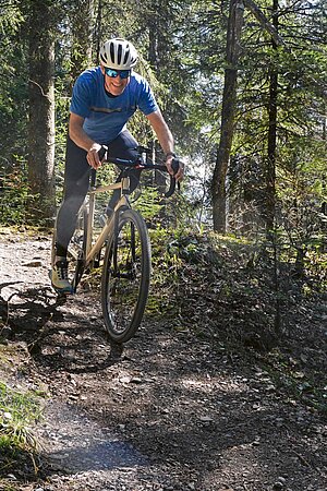 Ein Mann fährt im Wald mit einem Gravelbike.