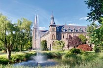 Veloreise zu den Trappistenklostern in Belgien. Klostergebäude mit Brunnen.