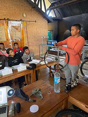 Ein Mann demonstriert die Arbeit an einen Laufrad für Fahrräder.
