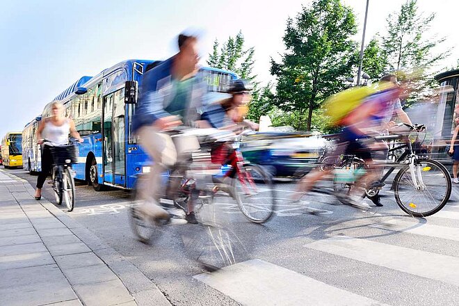Viele Menschen fahren mit Velos auf der Strasse.