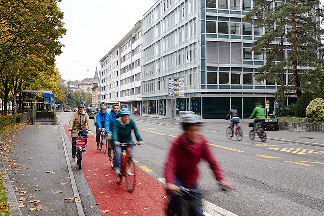 Radfahrende auf einem farblich markierten Veloweg in Bern